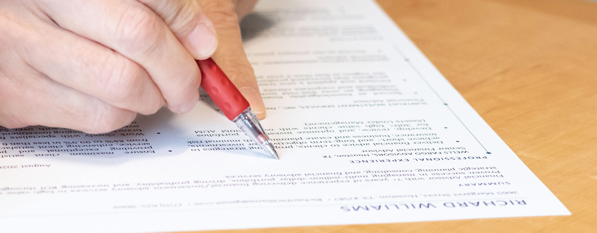 A close up of a librarian's hand reviewing a resume